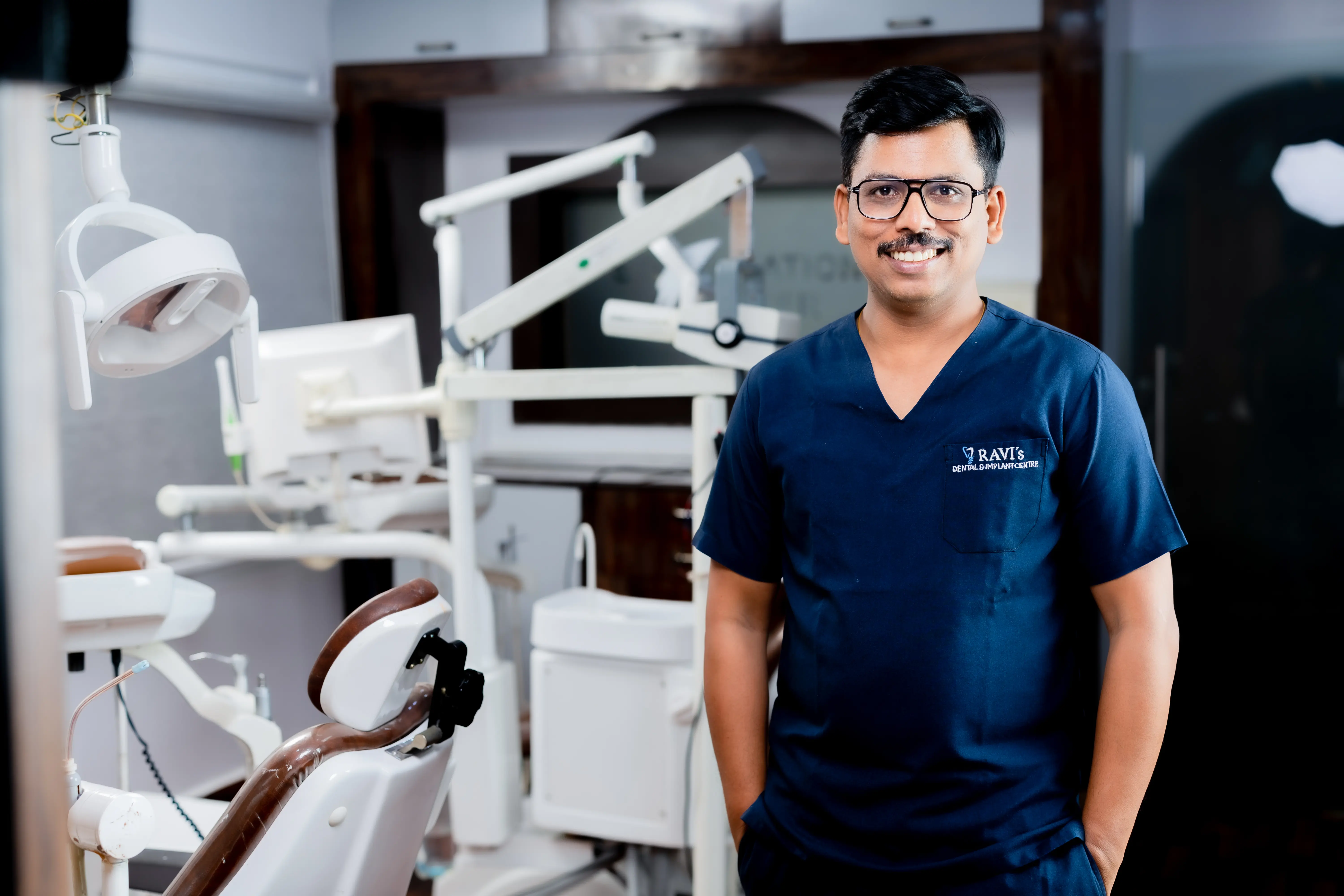 Dr. Ravi Kumar at consultation desk — Ravi&rsquo;s Dental Care & Implant Centre, MVP Colony Vizag