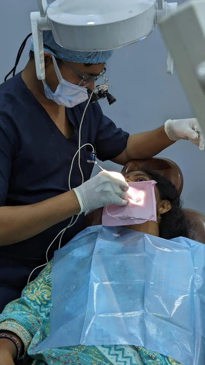 Dr. Ravi Kumar, MDS endodontist, performing root canal treatment under magnification loupes at his MVP Colony clinic in Vizag